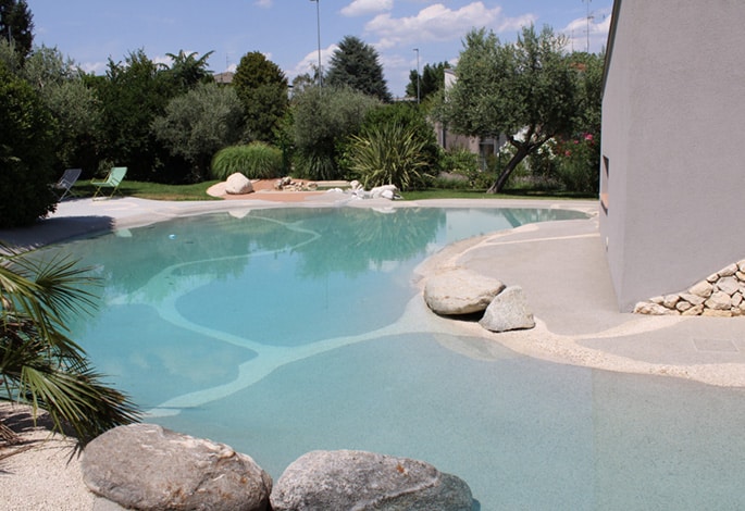 a Naturi pool surrounded by natural vegetation